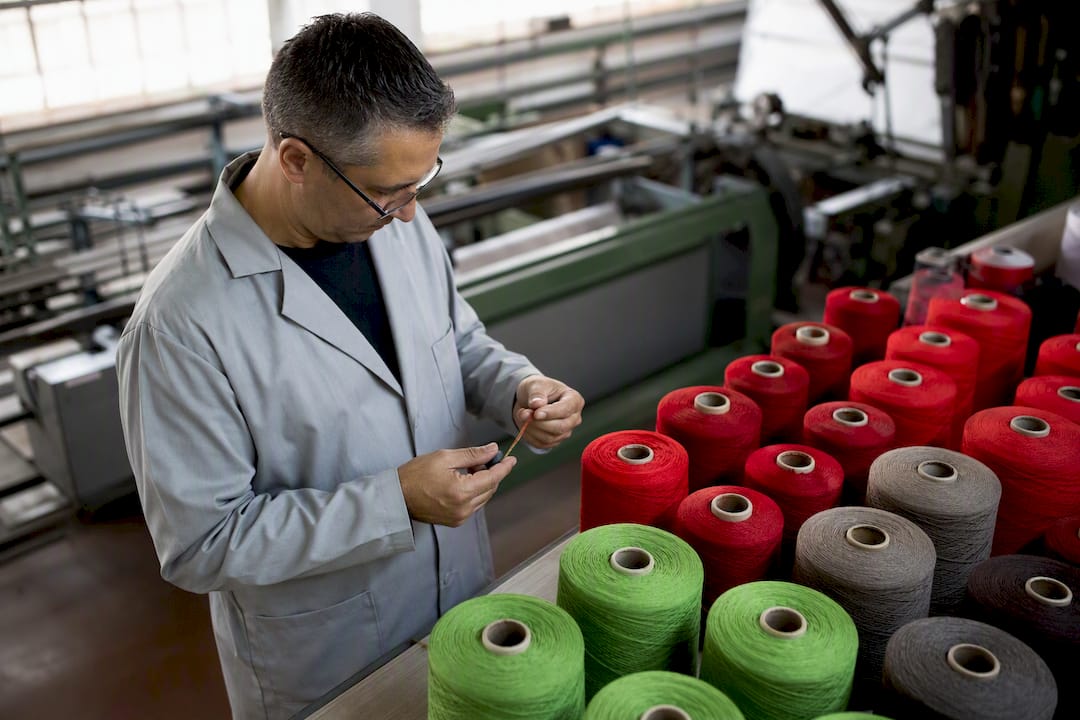 Manos de técnico inspeccionando la calidad del hilo