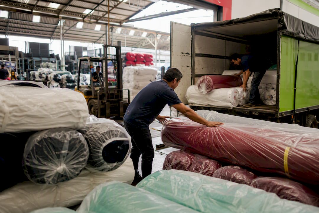 Personal de la fábrica textil cargando telas para su envío
