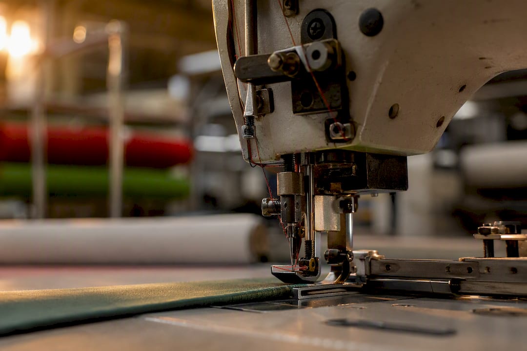 Primer plano del área de la aguja en una máquina de coser industrial